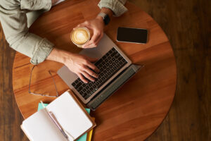 Person researching and writing about what is content marketing using a laptop and notebook.
